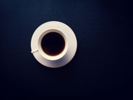 A cup of black coffee on a dark blue background