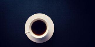 A cup of black coffee on a dark blue background