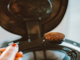 a woman putting espresso powder in a machine