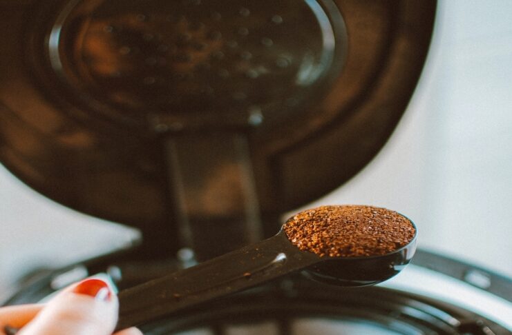 a woman putting espresso powder in a machine