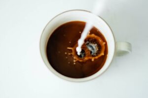 pouring milk in coffee