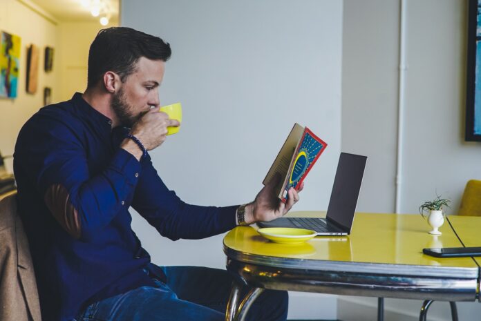 a person reading a book and drinking coffee