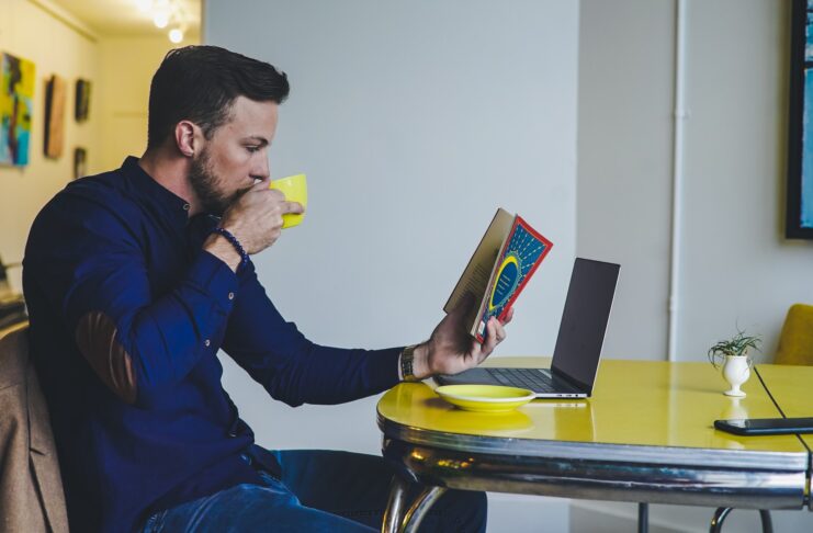 a person reading a book and drinking coffee