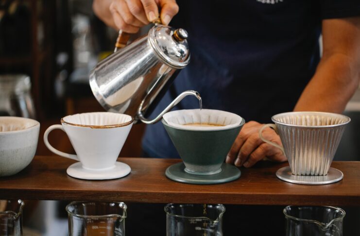 A person pouring coffee into cups