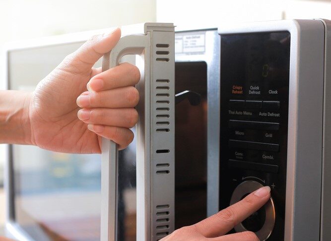 a woman opening a microwave