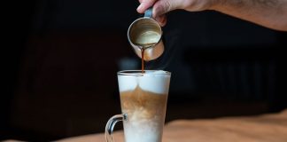 Latte macchiato with whipped cream and caramel sauce in tall