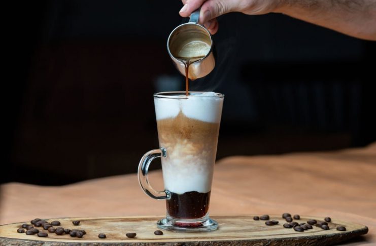 Latte macchiato with whipped cream and caramel sauce in tall